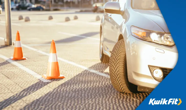 Driver practising reversing around traffic cones.