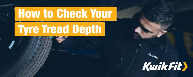 A Kwik Fit technician underneath a vehicle on a ramp in one of our Kwik Fit centres checking a tyre's tread depth.