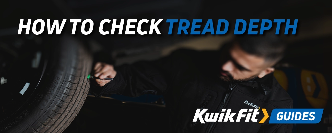 Technician checking the tread depth of a tyre on a car.