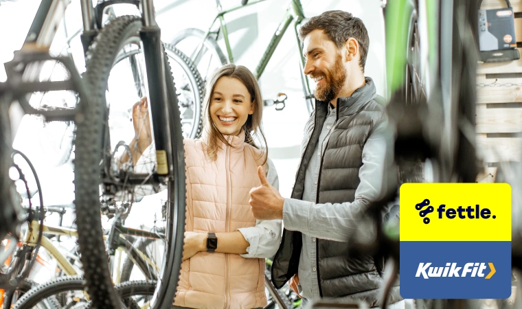 Two people looking at bikes in a shop.