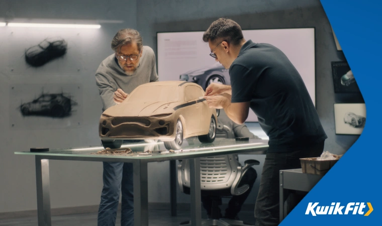 Two designers working on a replica of a car.