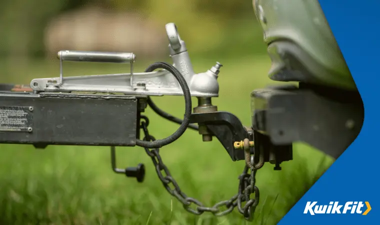 A tow-bar and breakaway cables connecting a trailer to a car.