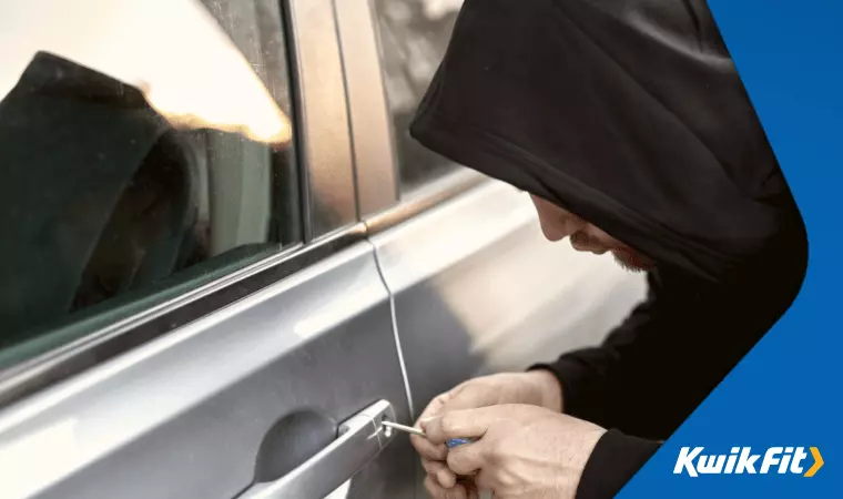 A thief breaks into an unattended car.