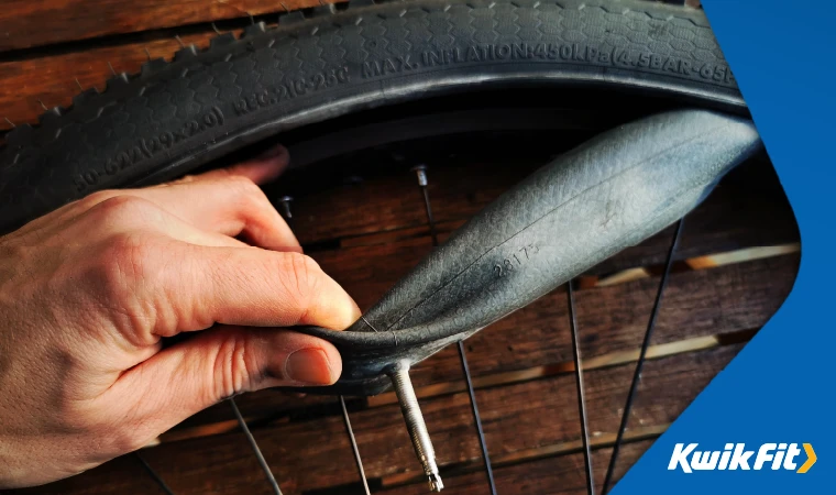 Person pulling bike tube from tyre.