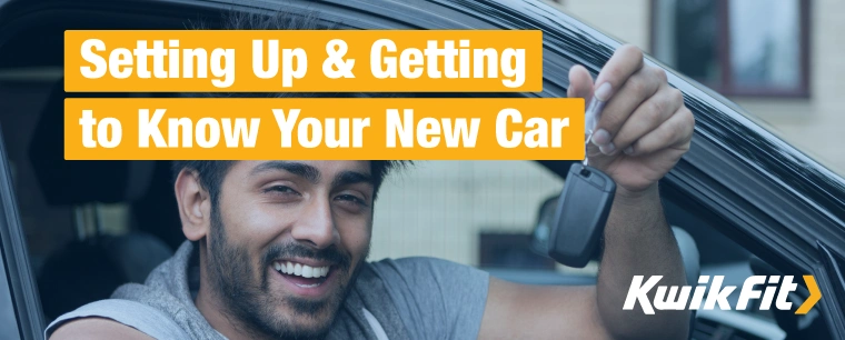 Man smiling in car whilst dangling his car keys out the window.